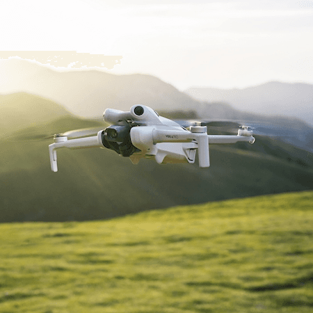 DJI Mini 4 Pro skrendantis virš kalnų